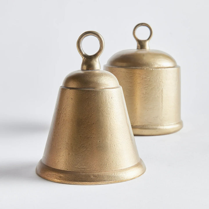 Two brass bells on a light gray background