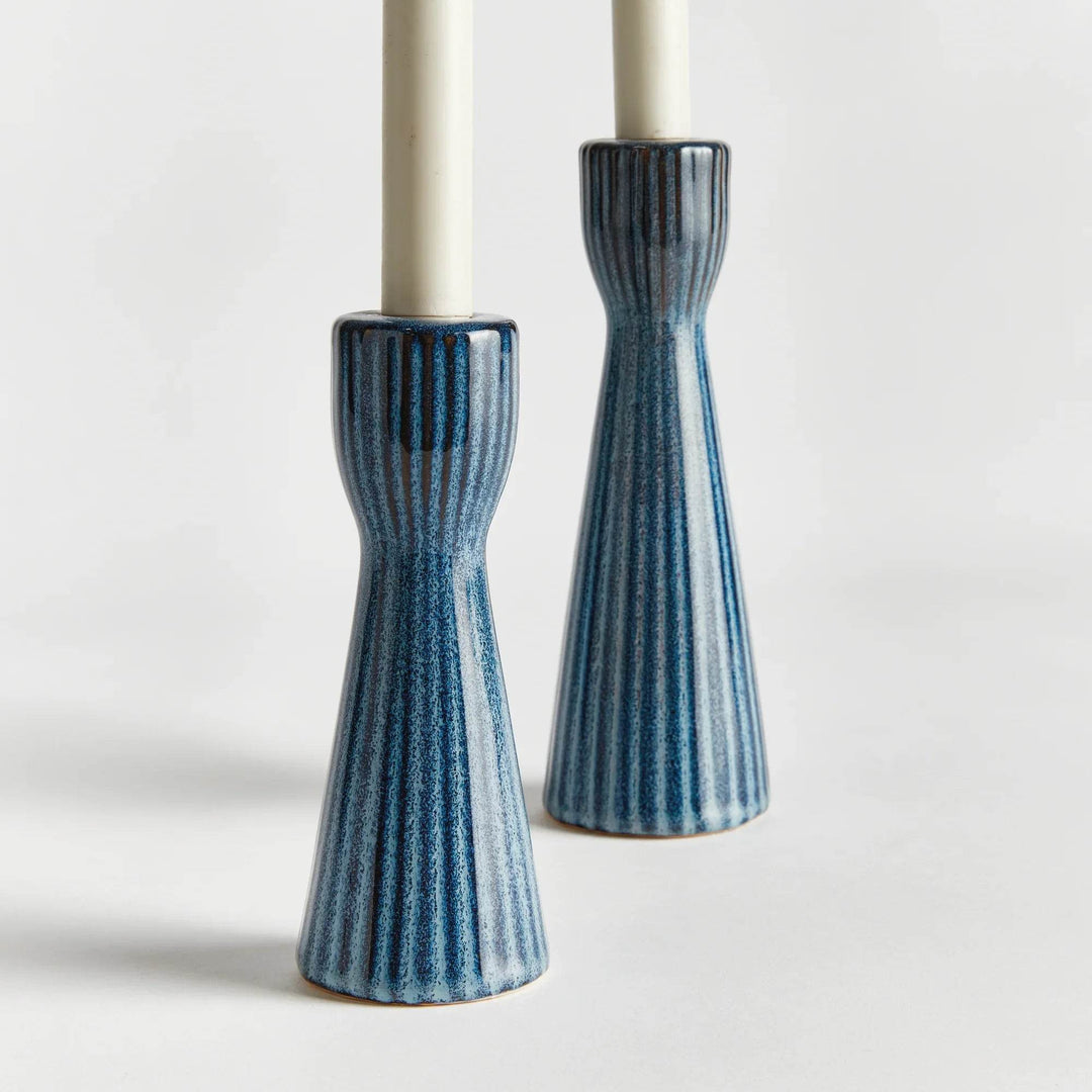 Blue stoneware candle holders shown with warm ambient lighting