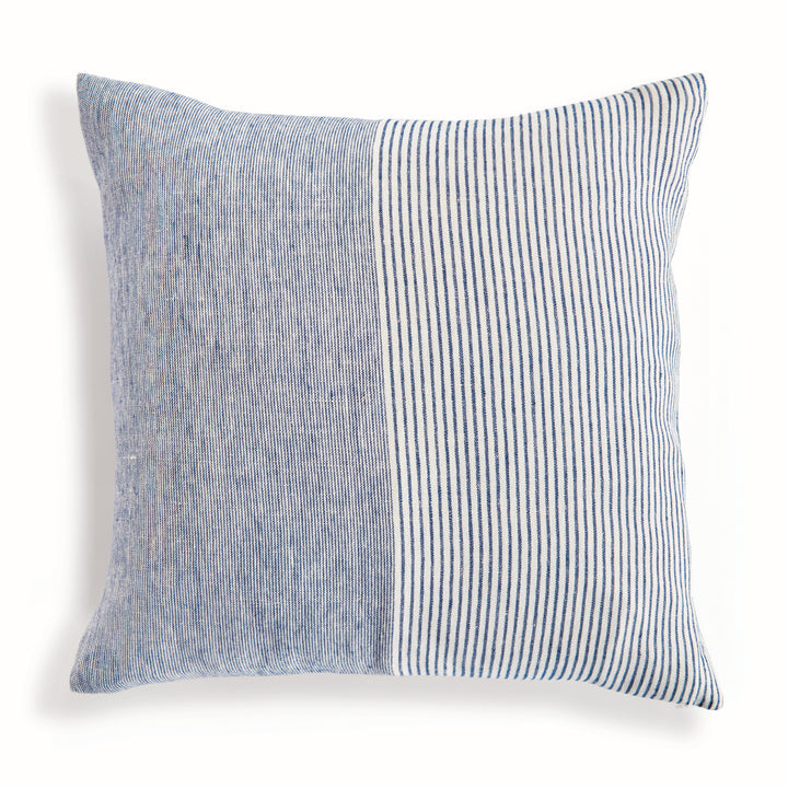 Navy and ivory pinstripe linen pillow styled on a neutral coastal sofa, 24-inch square size


