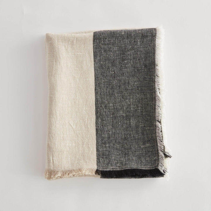 Close-up of linen throw blanket edge showing soft frayed fringe and weave pattern


