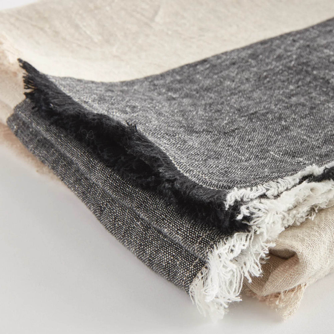 Lightweight linen throw blanket laid flat to show charcoal stripe and fringe details

