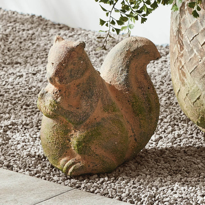 Front-facing view of rustic squirrel garden sculpture, capturing moss-toned accents and aged terracotta patina.

