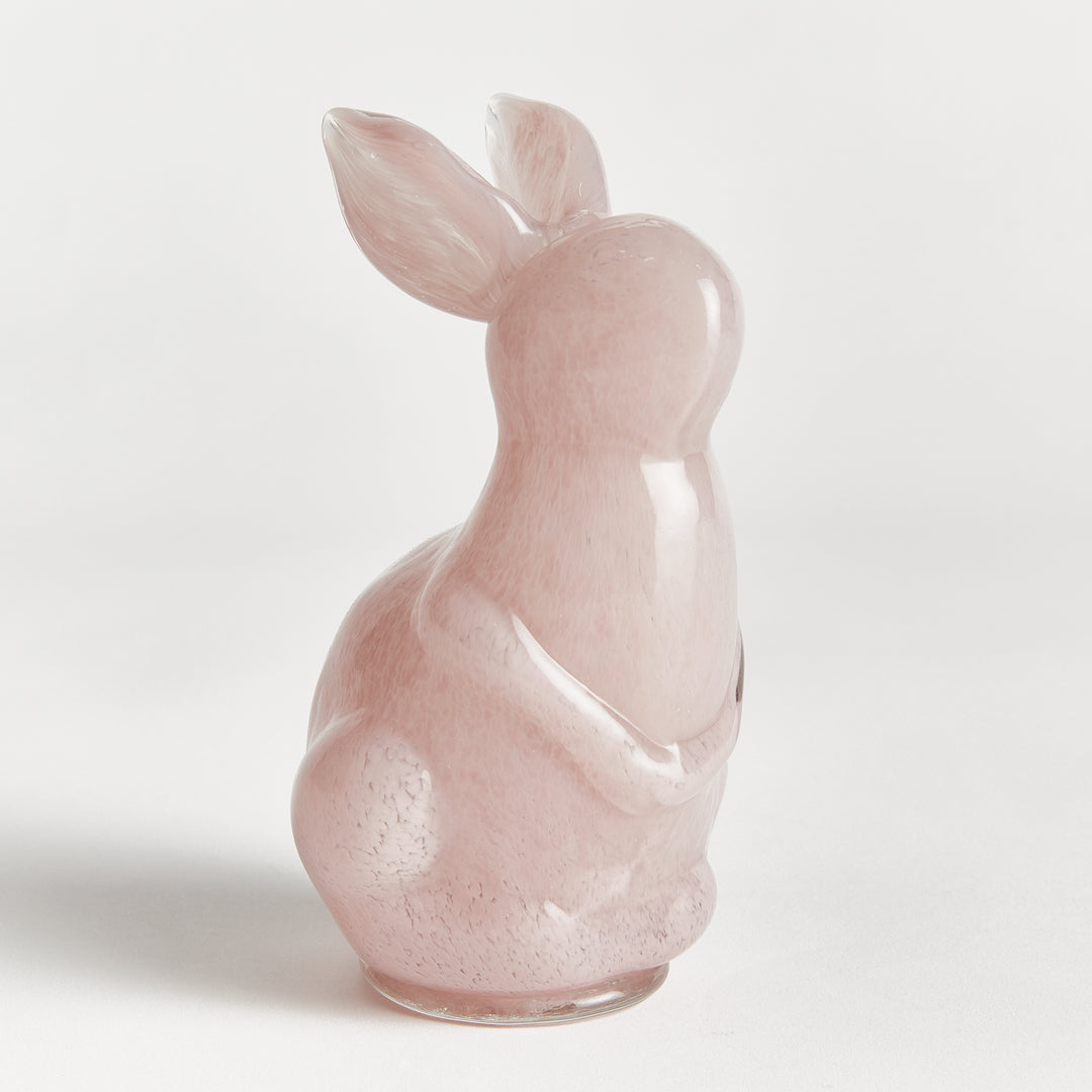 Pink rabbit sculpture on a light gray background