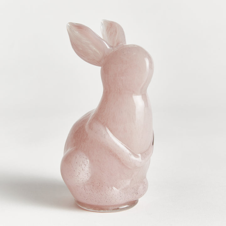 Pink rabbit sculpture on a light gray background