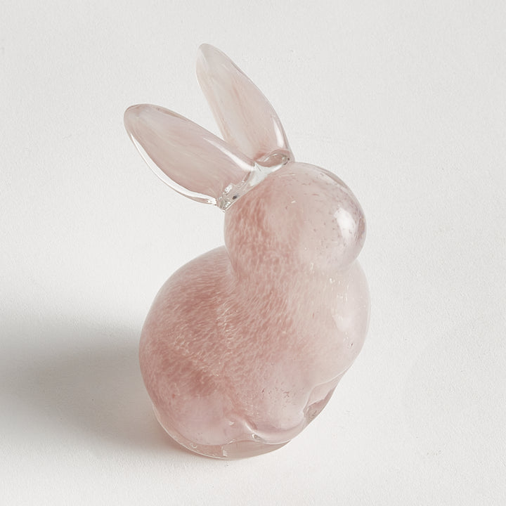 Pink glass rabbit figurine on a white background