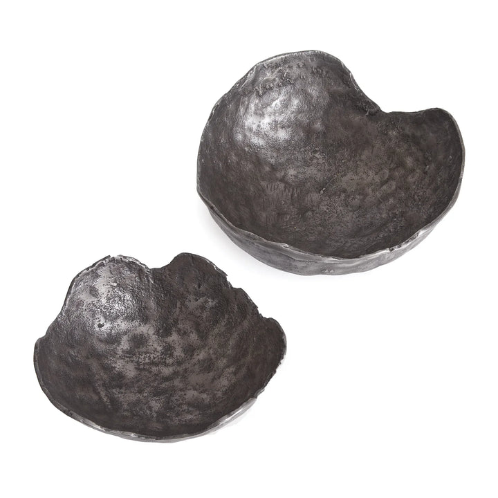 Two metallic, heart-shaped objects on a white background