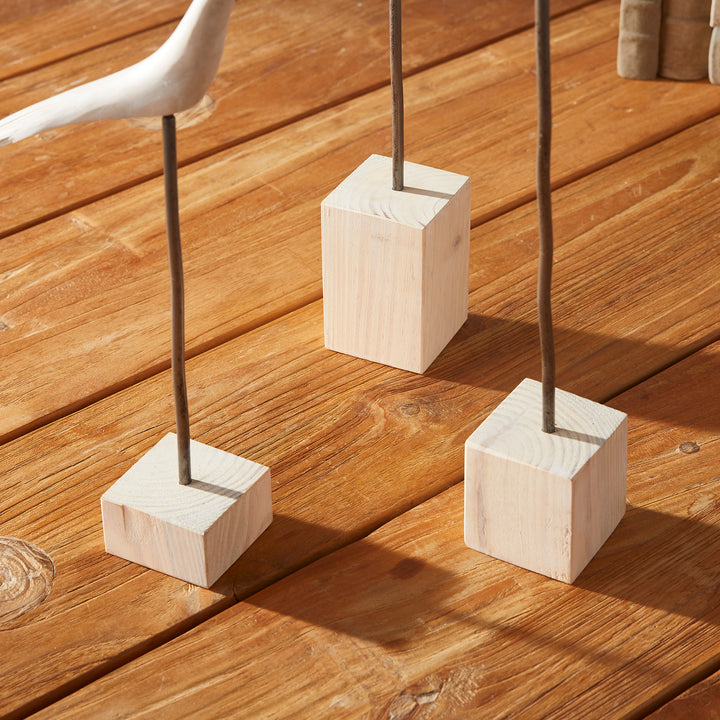 Three wooden blocks with metal rods on a wooden surface