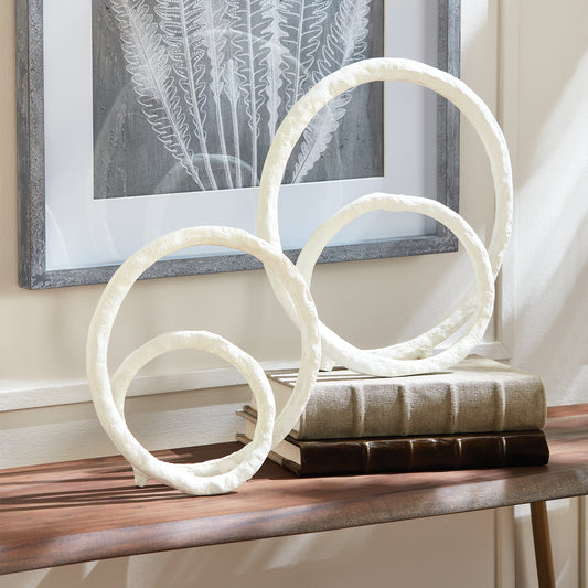 These two coordinating sculptures feature a modern matte white powder coat, adding sophistication to any space. Made of cast aluminum, they are both durable and aesthetically pleasing, with subtle coastal influences. Place them on a bookshelf, console, or mantel to instantly elevate your home decor.