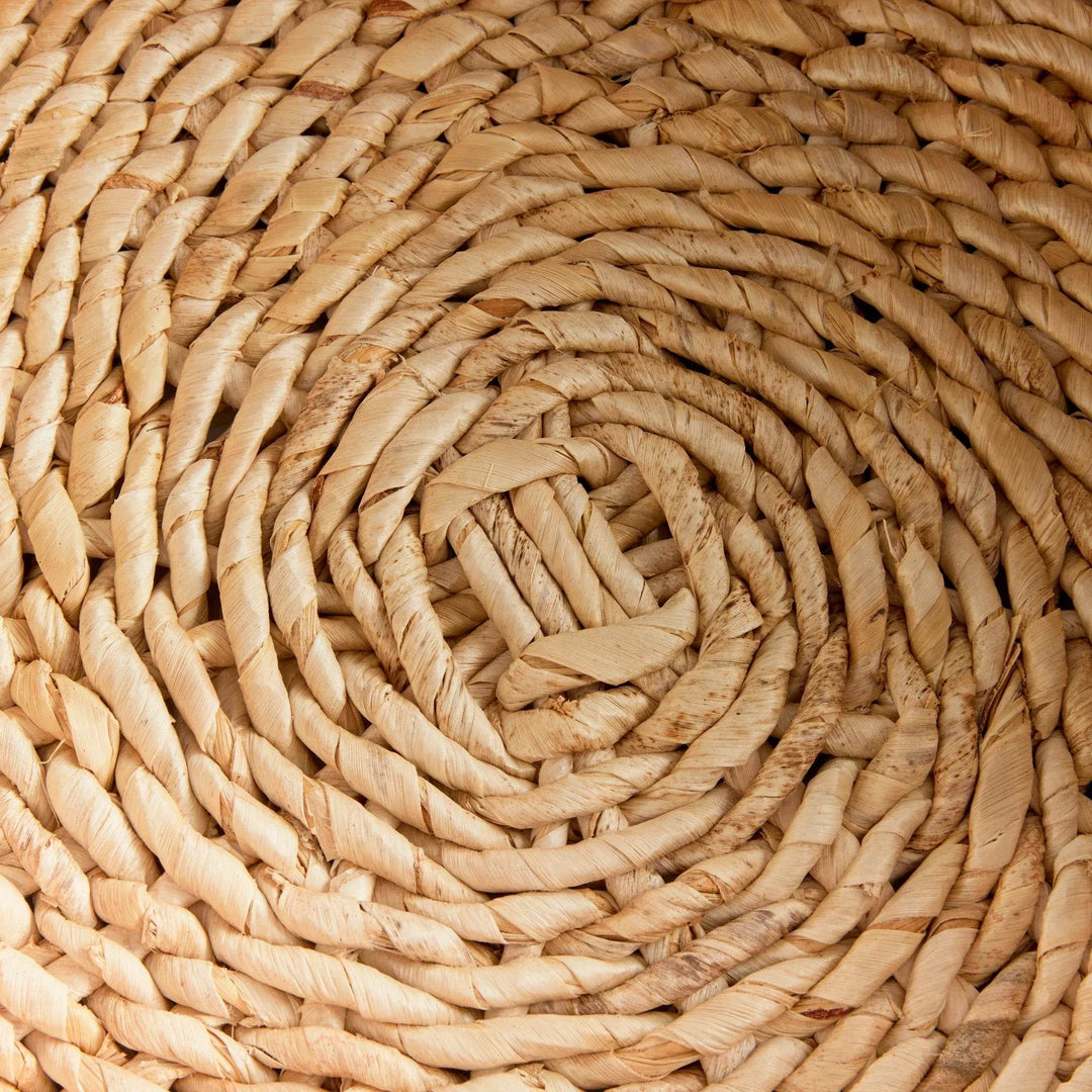 Closeup of base on handwoven abaca basket, showcasing spiral woven texture in natural fiber – Modern Farmhouse.