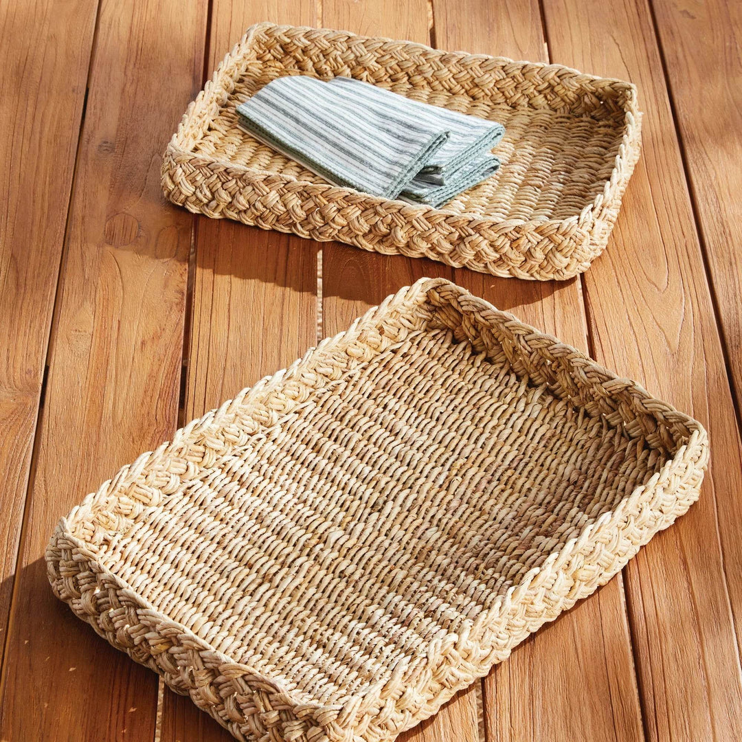 Natural abaca French braided rectangular tray holding striped cloth napkins on wood table