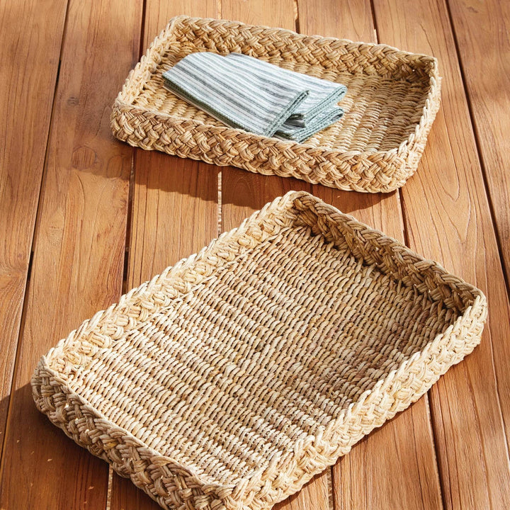 Natural abaca French braided rectangular tray holding striped cloth napkins on wood table