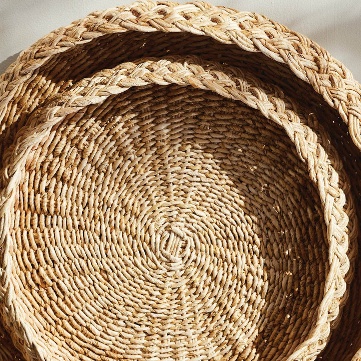 Overhead view of nested round abaca display trays set of two, showing interior weave and rim detail – Coastal.