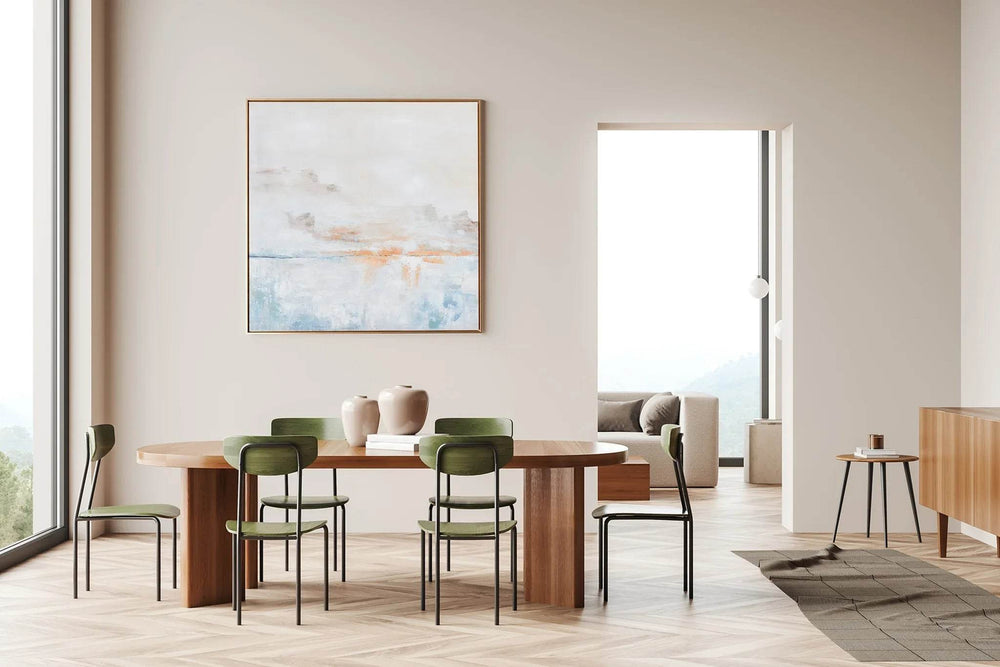 Oversized abstract canvas wall art in blue and orange displayed above dining table with green chairs – Modern Coastal