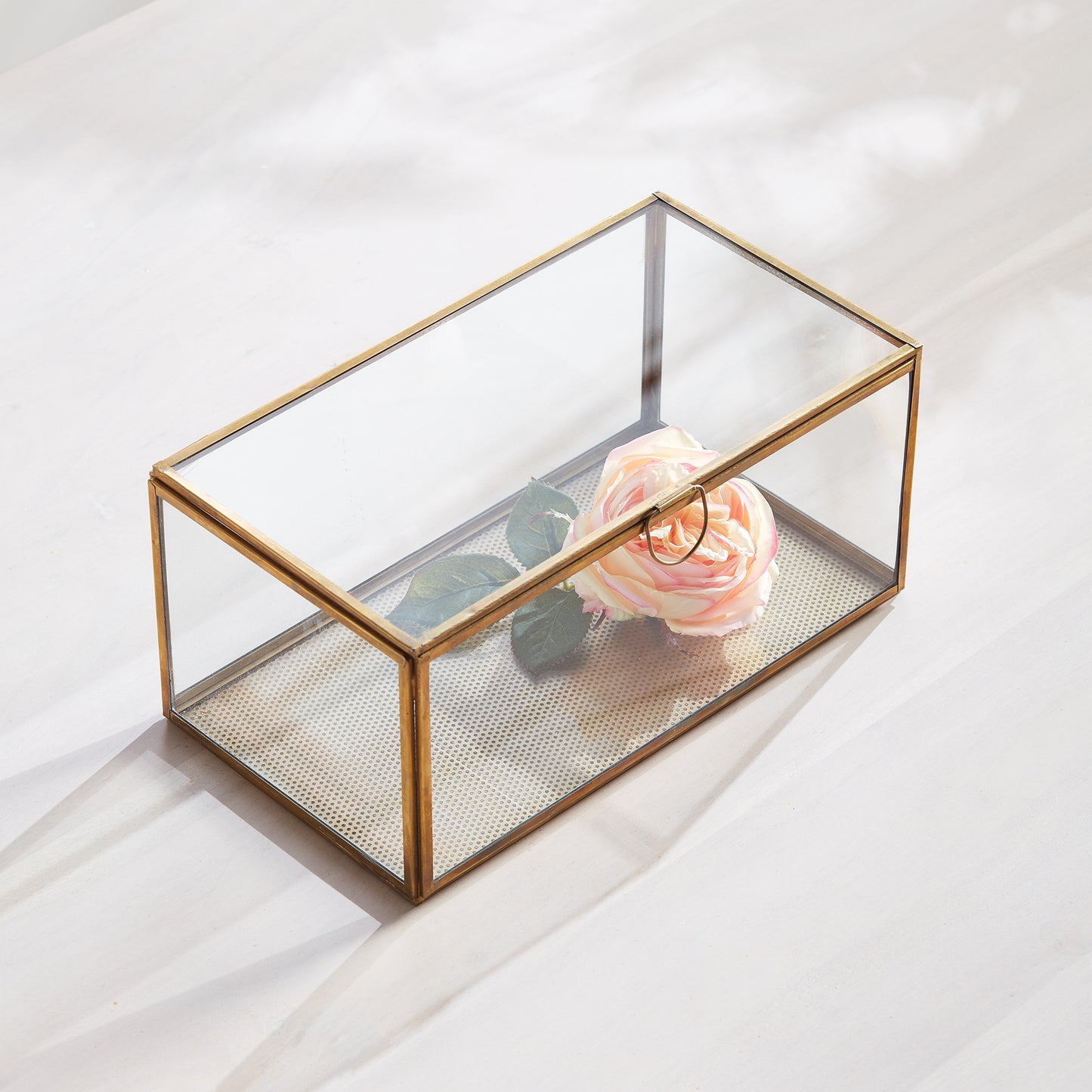 Expertly crafted with a combination of glass and brass, the Arwen Rectangular Antique Brass Display Box is designed to securely hold and protect your most cherished mementos. A sleek loop handle prevents fingerprints from marking the glass, keeping your keepsakes pristine.