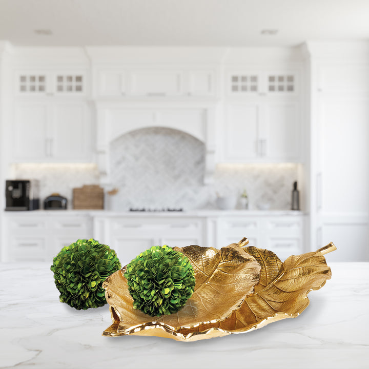 Each tray is carefully hand-carved using a clay mold to preserve the intricate leaf details. Constructed from aluminum, these trays are sturdy and adorned with a beautiful golden hue. Whether placed on a coffee table, console, or countertop, they are guaranteed to be the focal point.