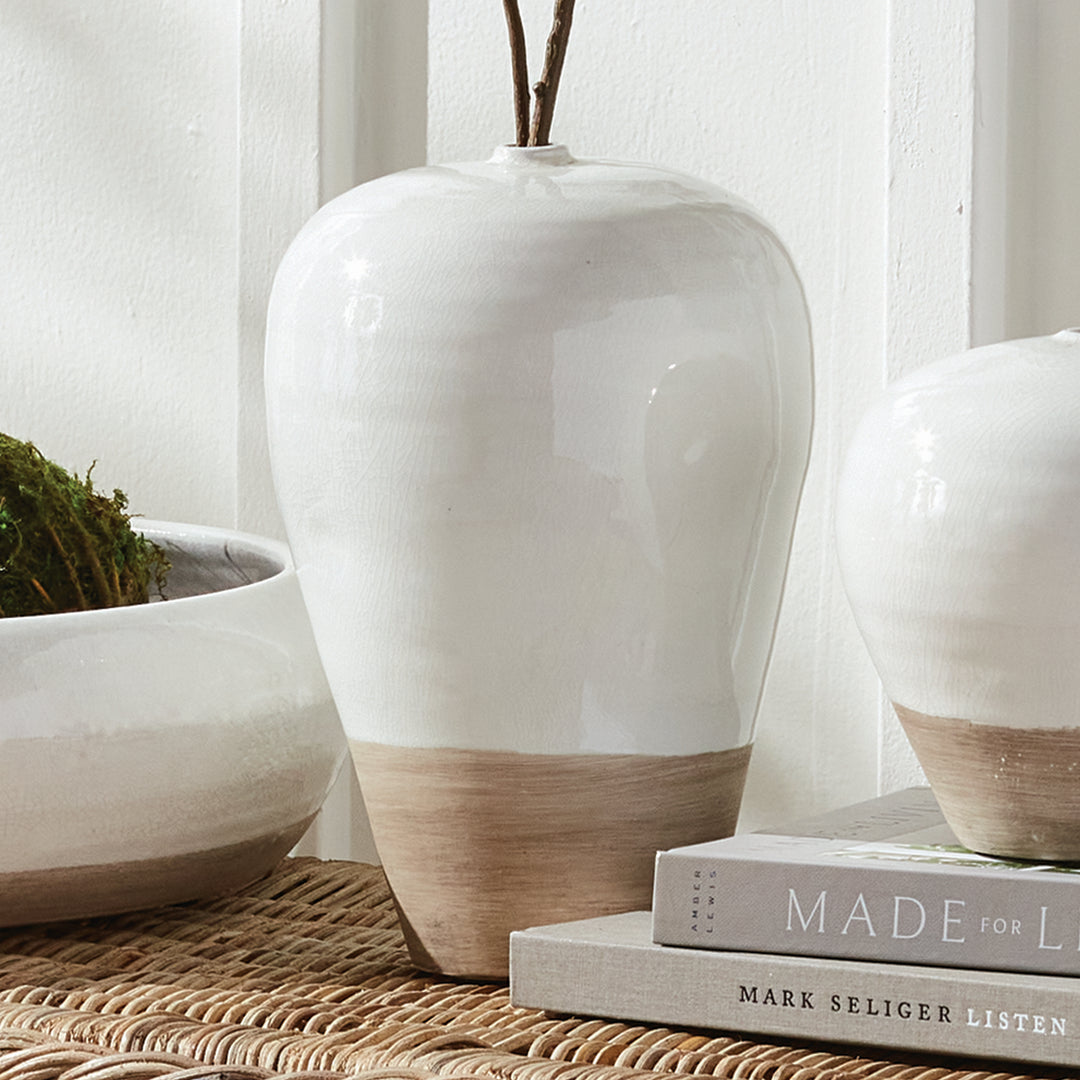 Alba large white vase with decorative stems beside the white bowl and small vase on woven furniture by books. Modern Organic