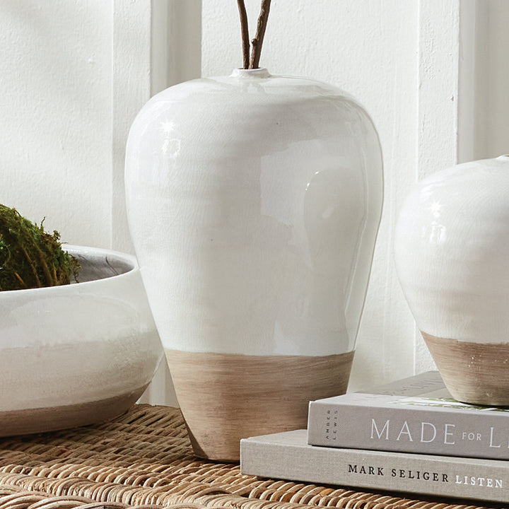 Alba large white vase with decorative stems beside the white bowl and small vase on woven furniture by books. Modern Organic