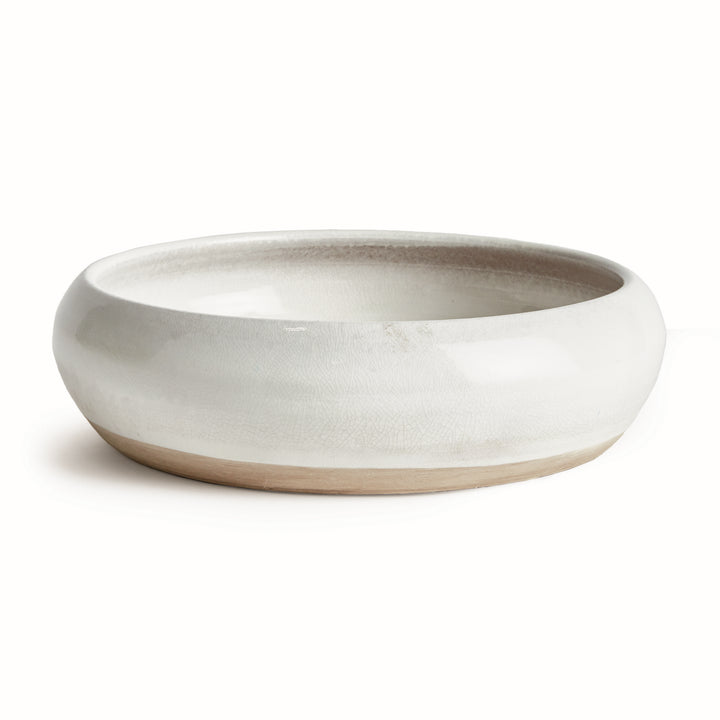 Alba white terracotta bowl with glossy reactive glaze, rounded rim and natural clay base on a pale background. Modern Organic