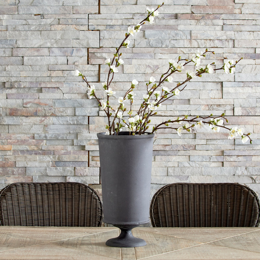 Large decorative metal urn vase with faux stems and aged zinc finish in rustic European style