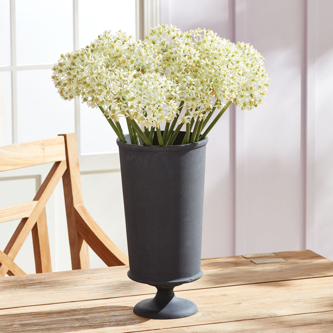 Decorative metal urn vase with white faux floral arrangement in transitional interior style