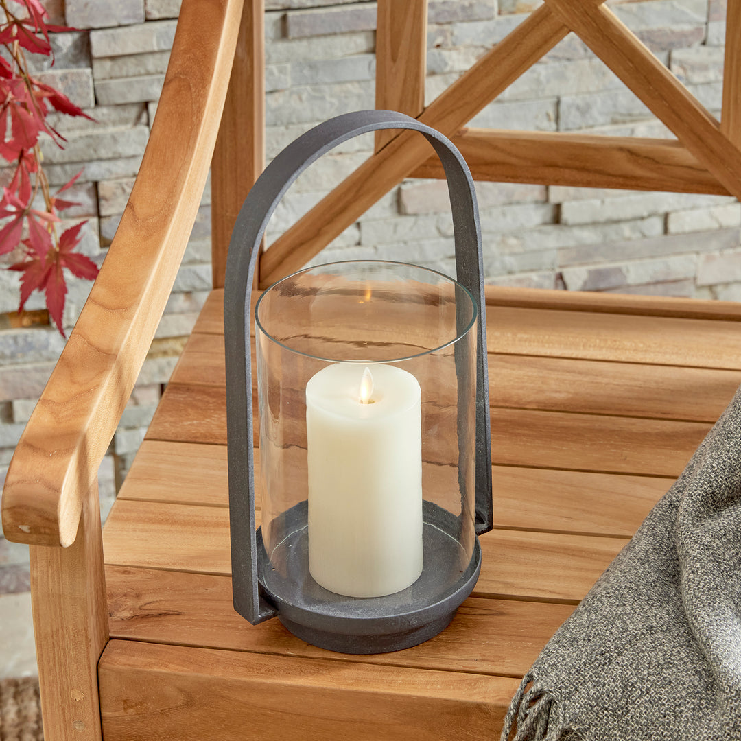 Outdoor hurricane candle holder with aged zinc finish styled in a relaxed indoor-outdoor entertaining space – Transitional style.