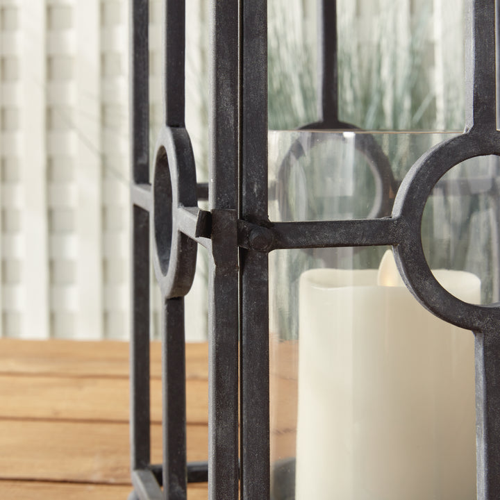 Close-up detail of outdoor metal candle holder with circular iron accents and aged zinc finish – Industrial Outdoor style.