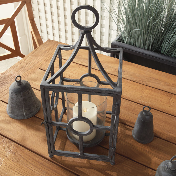 Outdoor metal candle holder styled on a patio with layered textures and lantern-inspired architectural detailing – European Garden style.