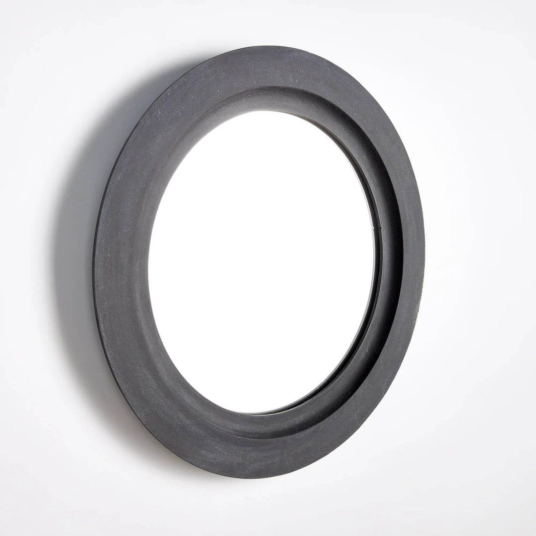 Angled view of round metal wall mirror with deep molded frame and aged-metal character – Modern Organic style.
