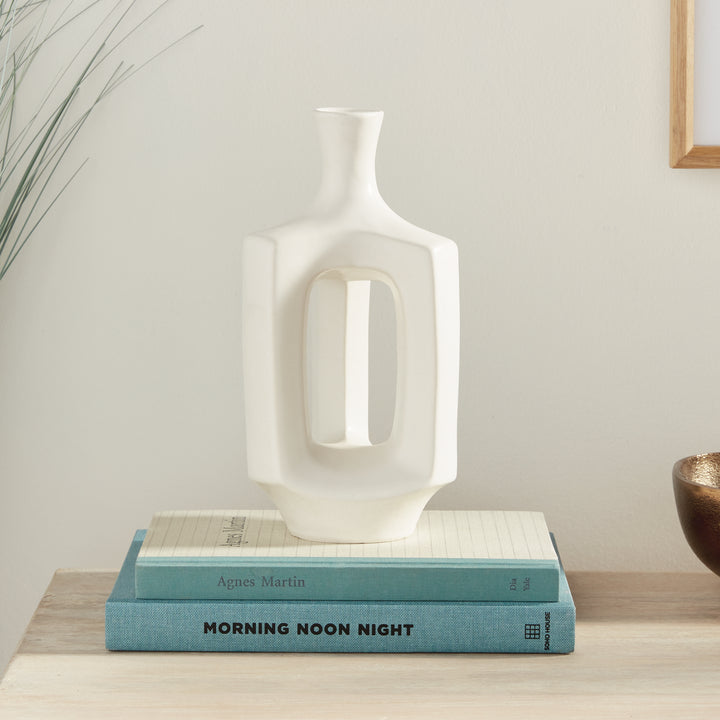 Medium white clay vase, styled on books beside neutral decor, with a narrow neck and an open white frame. Modern Organic