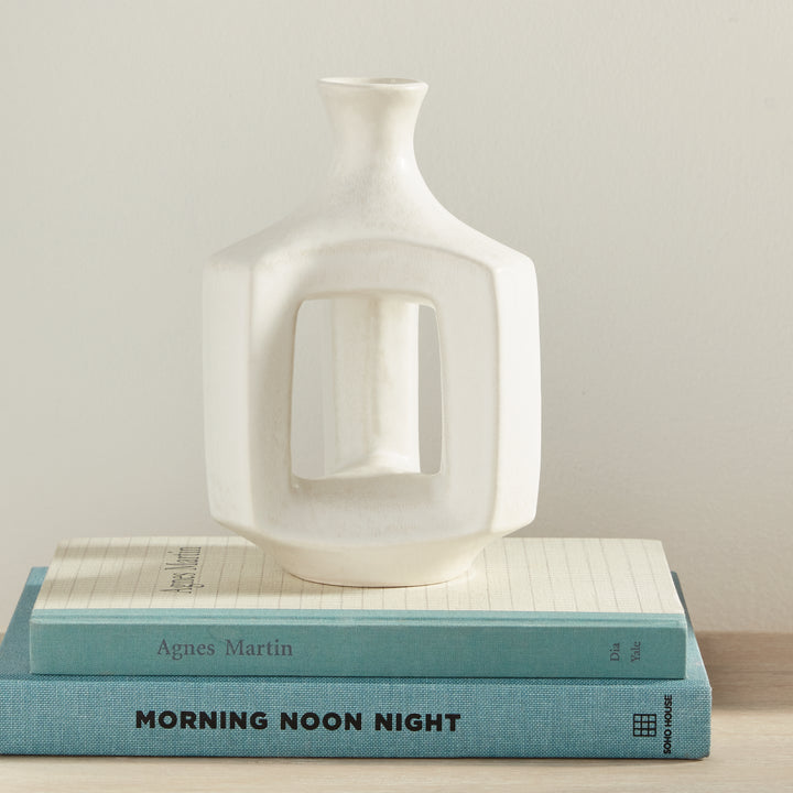 Short matte white clay vase, styled on books beside neutral decor, with a narrow neck and an open white frame. Modern Organic