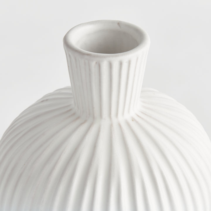 Close detail of a white terracotta vase neck and shoulder, showing the open mouth and vertical ribbed relief. Transitional