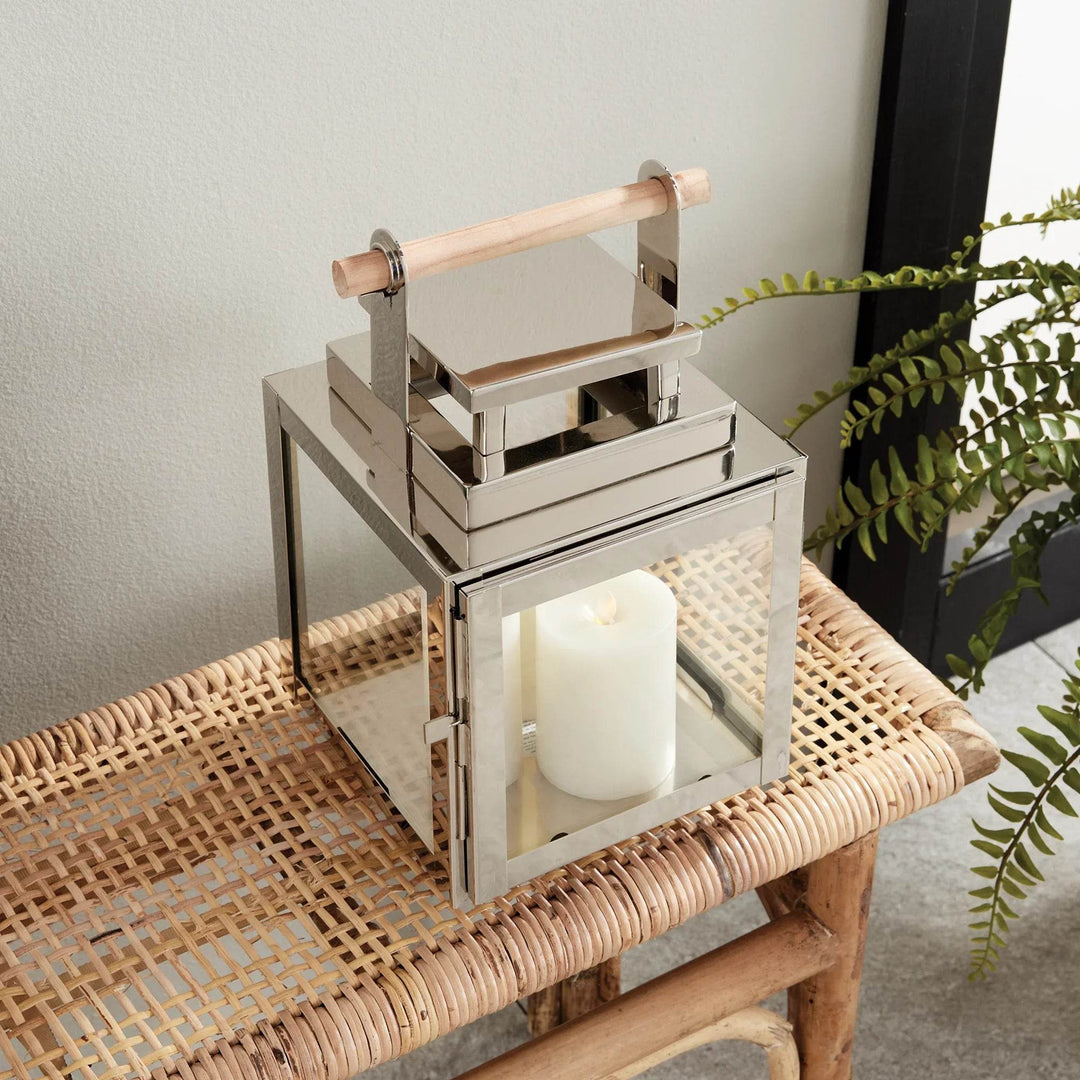 Outdoor lantern in silver with teak handle, angled view styled on bench