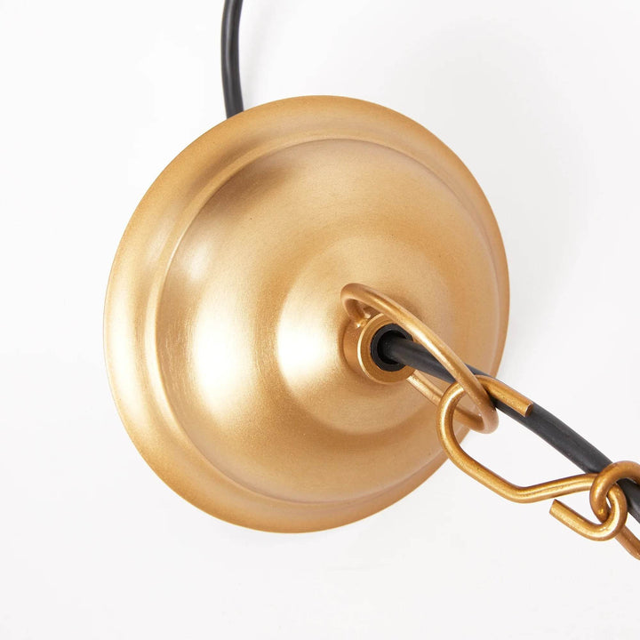 Gold pendant ceiling canopy close-up showing a round metal plate, matching chain links and a dark cord, Transitional style