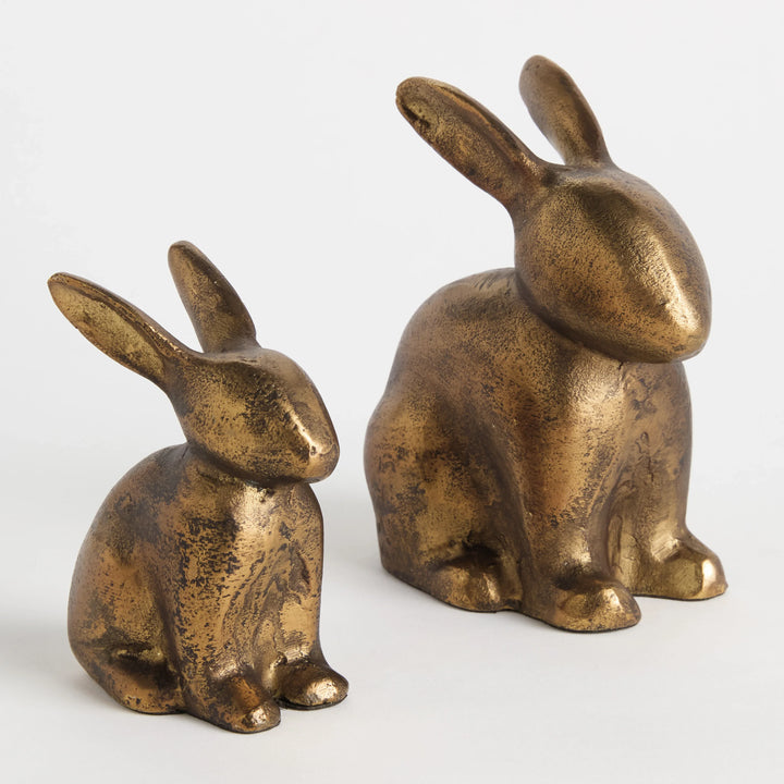 Set of two seated rabbit figurines in antique brass finish shown from angled side view for bookshelf decor Traditional Transitional style