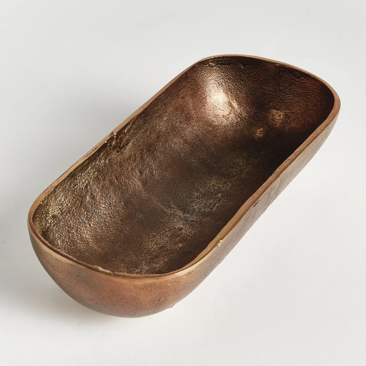 Small antique brass narrow decorative bowl end view highlighting curved depth and sculpted organic shape modern organic