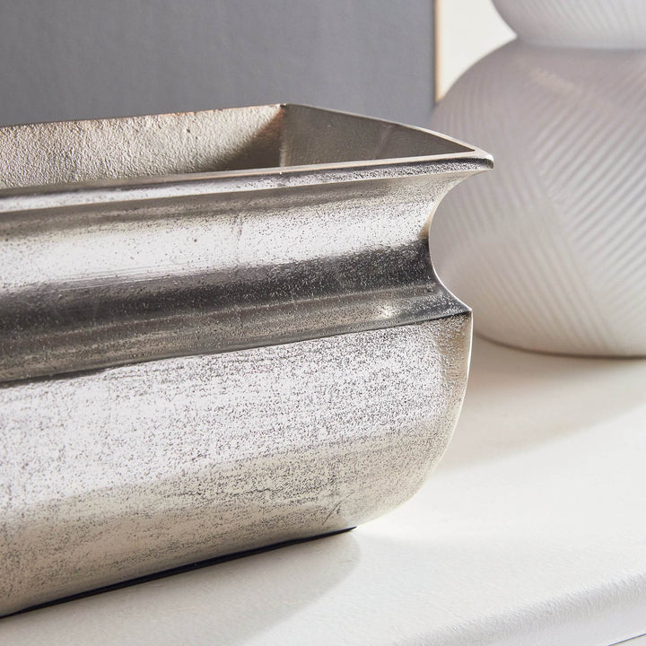 Close-up detail of antique silver vase finish and textured surface

