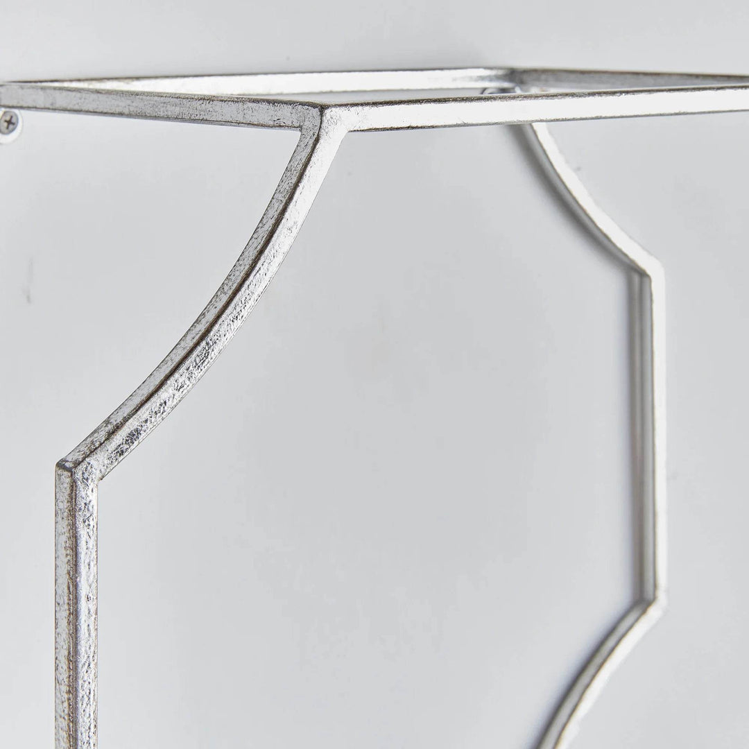 Detailed angle of the geometric silver metal frame on mirrored wall shelf, Art Deco-inspired