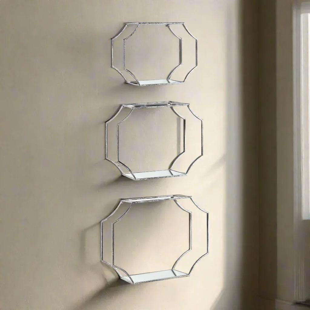 Styled view of three Art Deco-inspired silver wall shelves mounted on a neutral wall