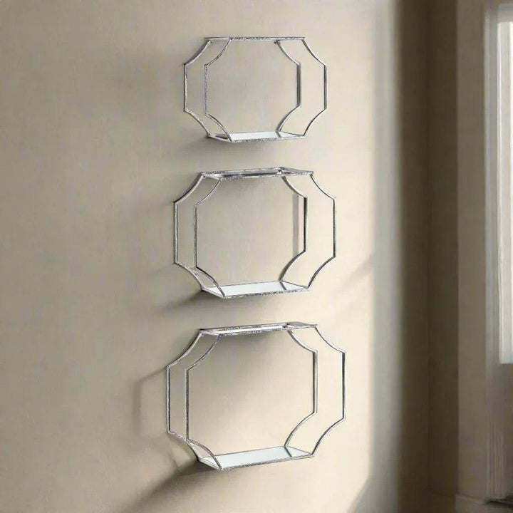 Styled view of three Art Deco-inspired silver wall shelves mounted on a neutral wall