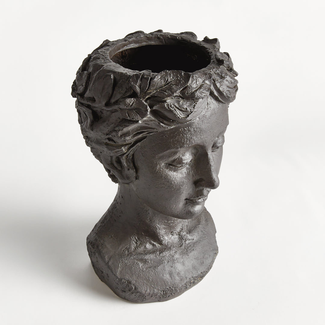 Angled view of an antique black female bust planter, showing the circular planting opening and sculpted hair. Transitional