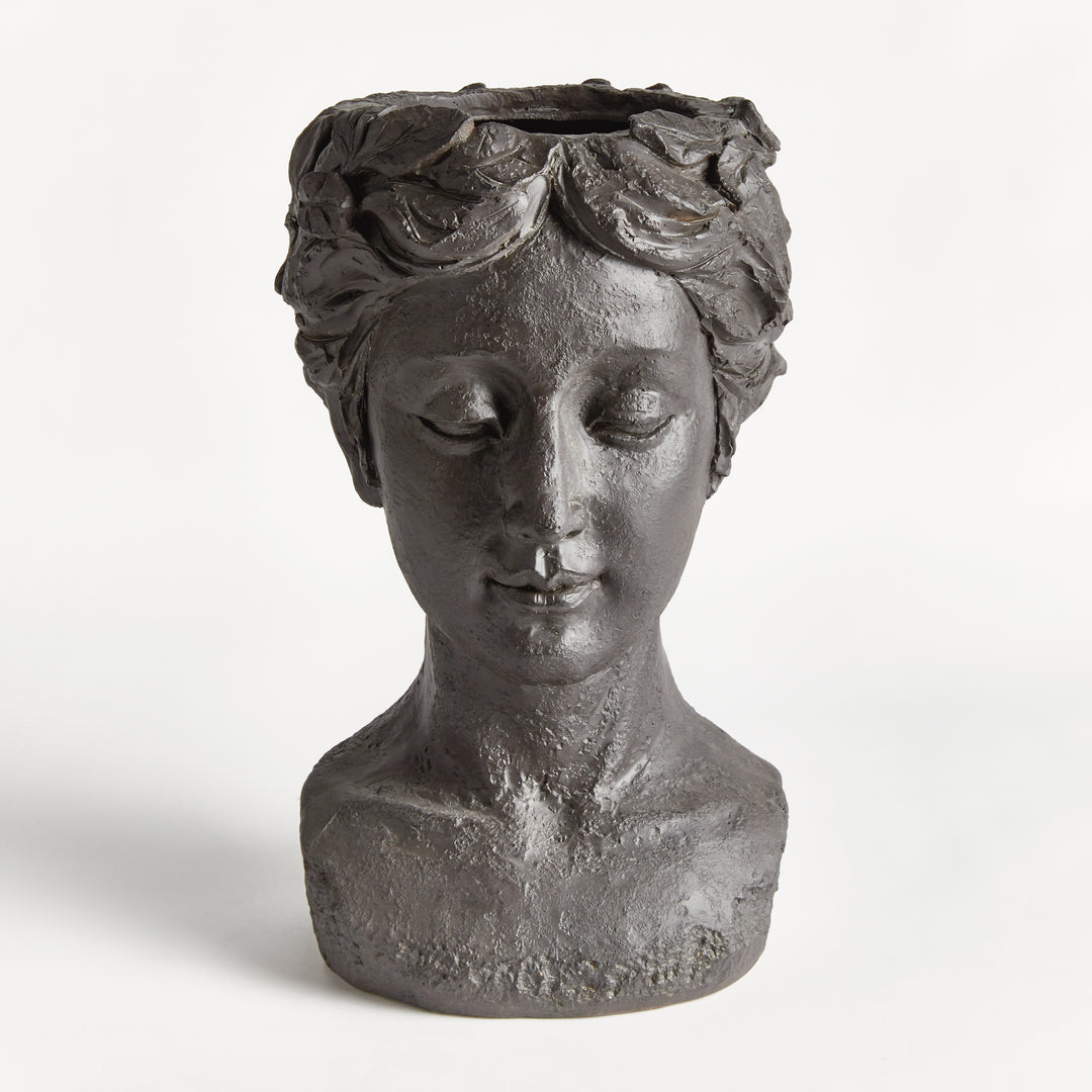 Front view of an antique black female bust planter showing its classical face, sculpted hair and rounded base. Transitional