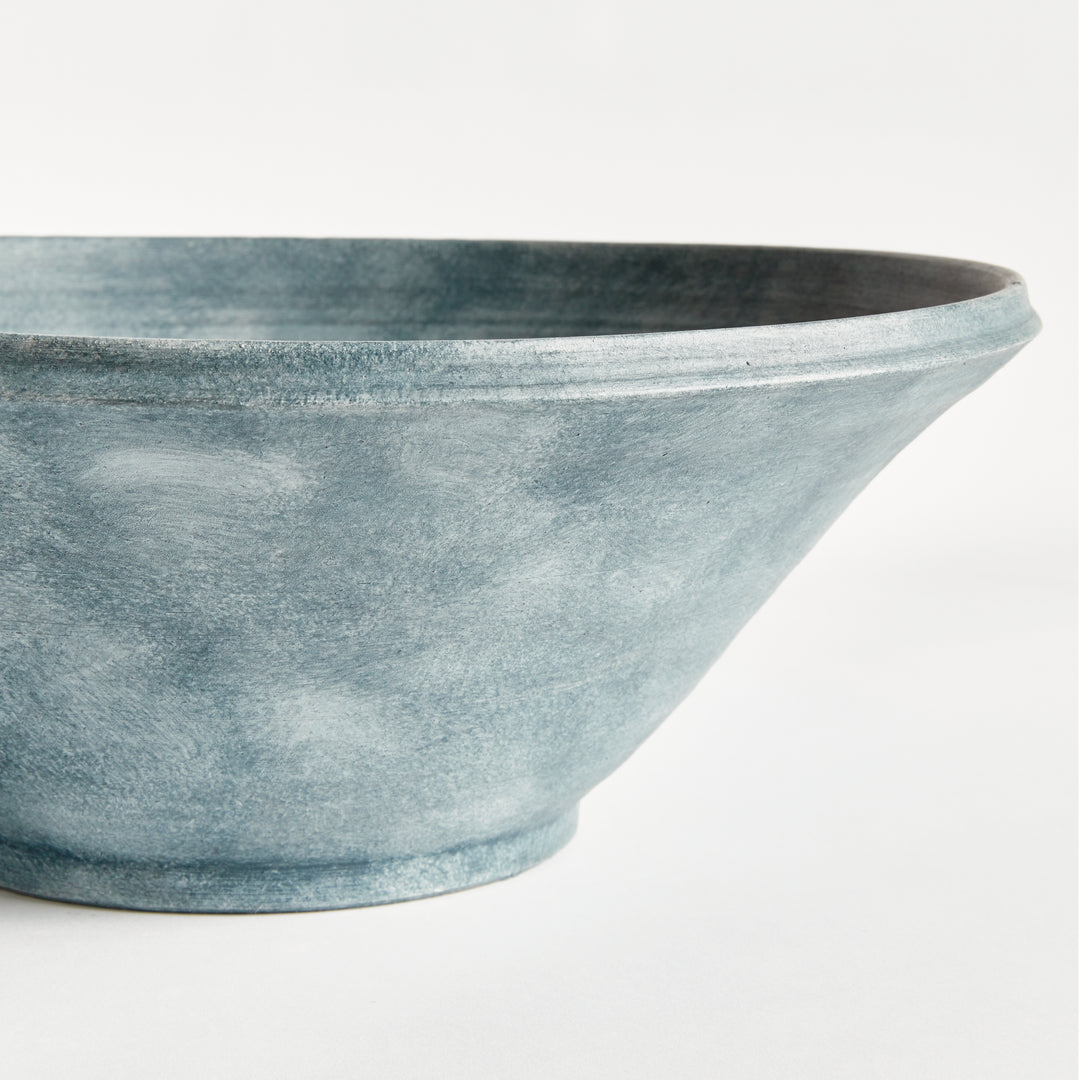 Close view of Aveline washed blue terracotta bowl showing its curved rim, horizontal ribbing and tapered base. Modern Organic