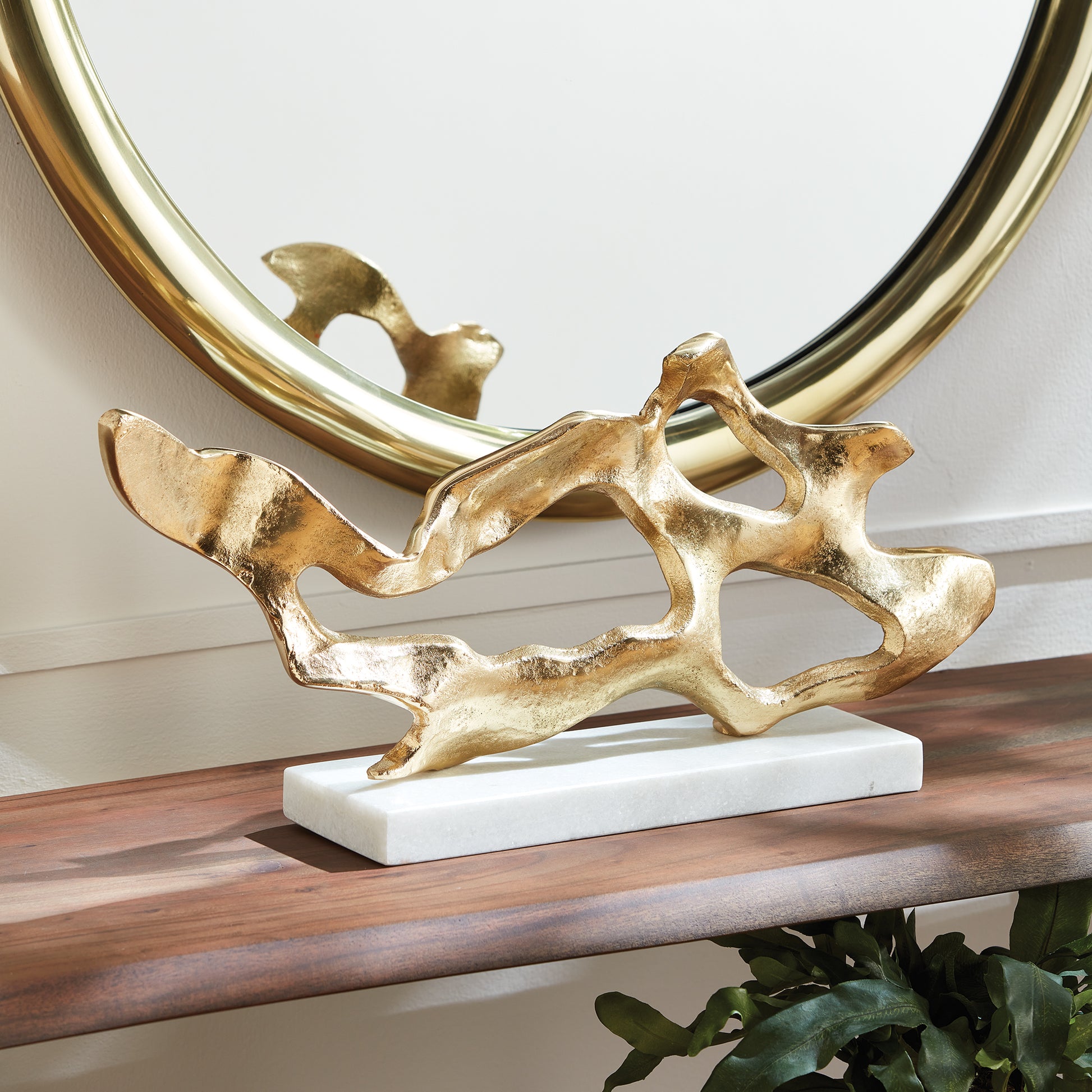 Enhance your coastal design with this striking abstract sculpture inspired by driftwood. Resting on a sleek white marble base, creating an elevated and luxurious atmosphere. This one-of-a-kind sculpture adds a sophisticated touch to any living space, expertly crafted with a unique driftwood-inspired design. Perfect for displaying on a shelf or table, it adds an upscale and polished touch to your coastal decor.