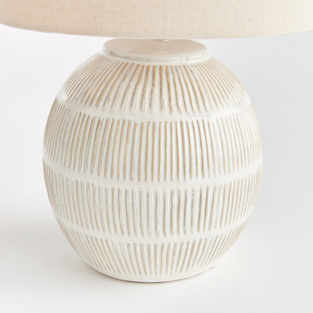 Featuring a rounded ceramic body with a hatch mark pattern, the Antoni White Table Lamp brings character to any space. The natural linen shade serves as a lovely accent on a bedside table, side table, or desk in a living room or dining area.