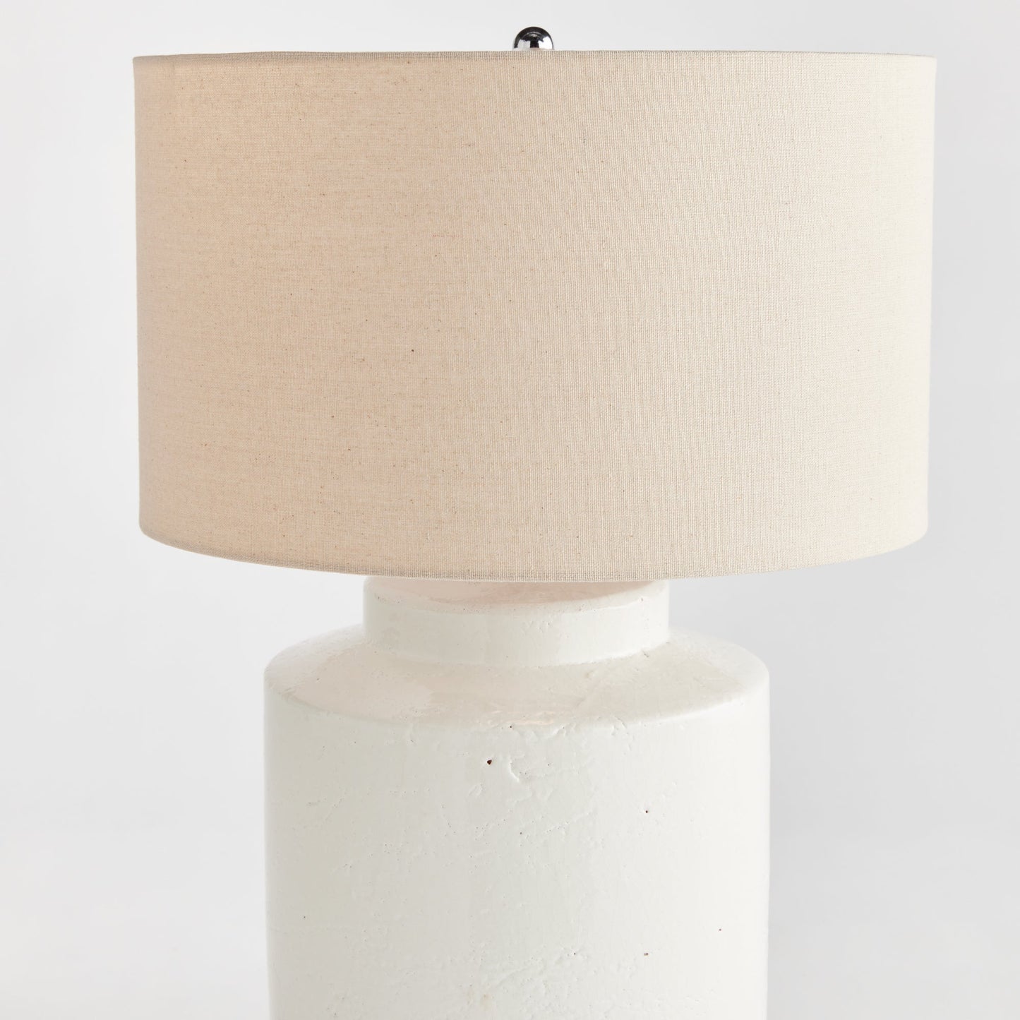 This Monty White Transitional Table Lamp is crafted from elegant white ceramic with a thick glaze, making it a perfect addition to transitional décor. Its generously-sized white linen shade and sleek finial add a touch of sophistication to its timeless design. The table lamp's construction is elegant and durable, creating a lasting beauty that will elevate any space. Add character and style to any room with this versatile and sophisticated lamp.