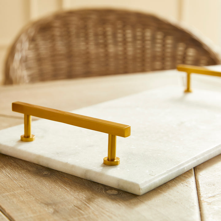 This Marble Serving Tray features a timeless pairing of marble and brass, making it the perfect way to present your favorite cheese and cracker platters. Its versatile design is suitable for coastal, traditional, and transitional settings, elevating your hosting game with a touch of sophistication. Whether you're serving a decadent cheese platter or a simple cracker spread, this tray is sure to impress, adding an elegant touch to any occasion.