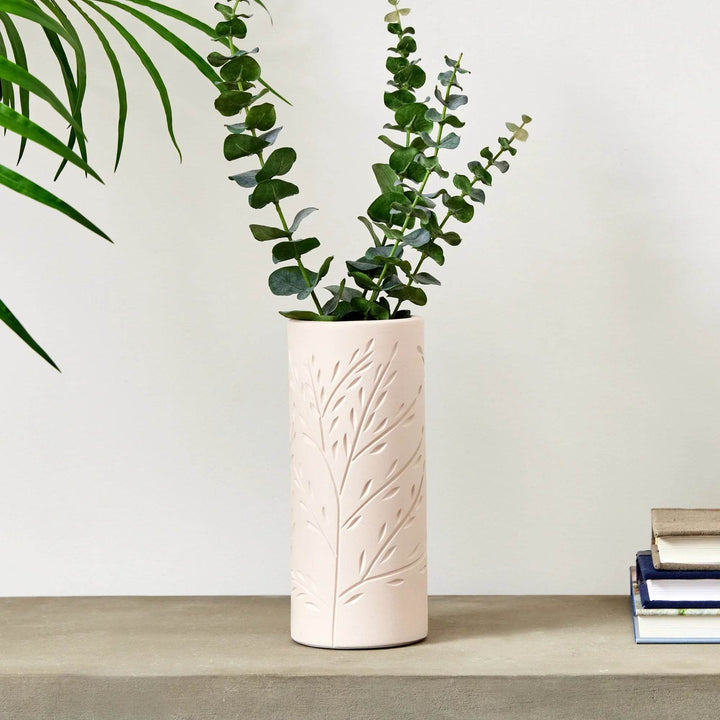 Handcrafted beige terracotta vine motif vase styled with greenery, modern organic decor accent for shelves or consoles.

