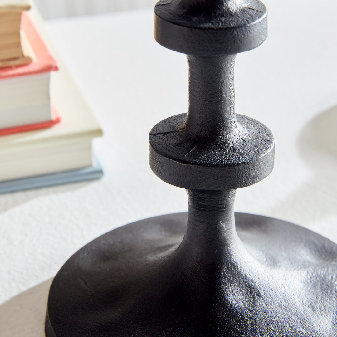 Close-up of black aluminum candle holder base with textured sculptural pedestal detailing – Transitional