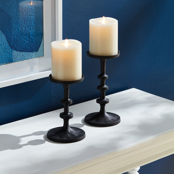 Black aluminum candle holders with stacked detailing styled on a modern console table – Transitional