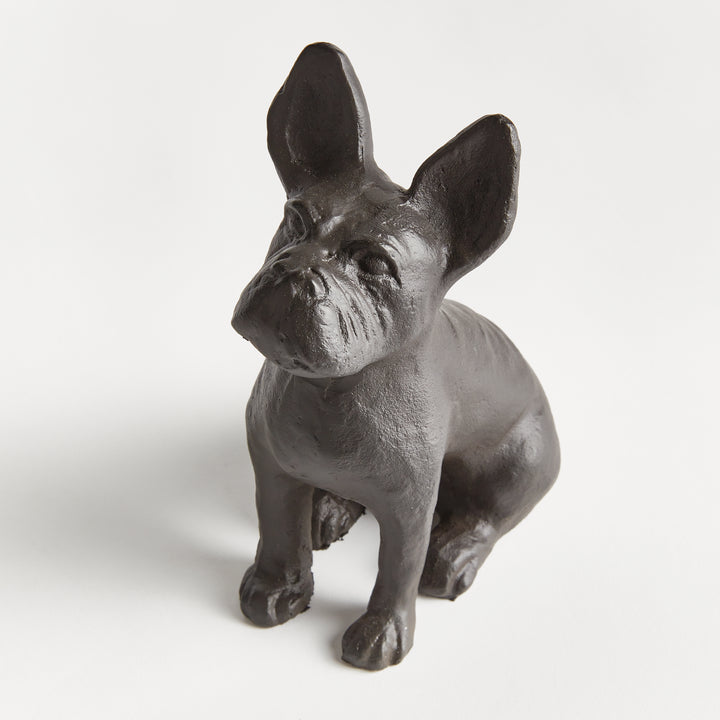 Close-up of dog figurine from the front, highlighting cast aluminum texture and alert expression in a sculptural seated pose.